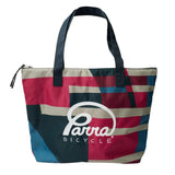 Colorful tote bag with 'Parra Bicycle' logo on a light gray background