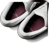 White sneakers with a dark purple insole on a white background